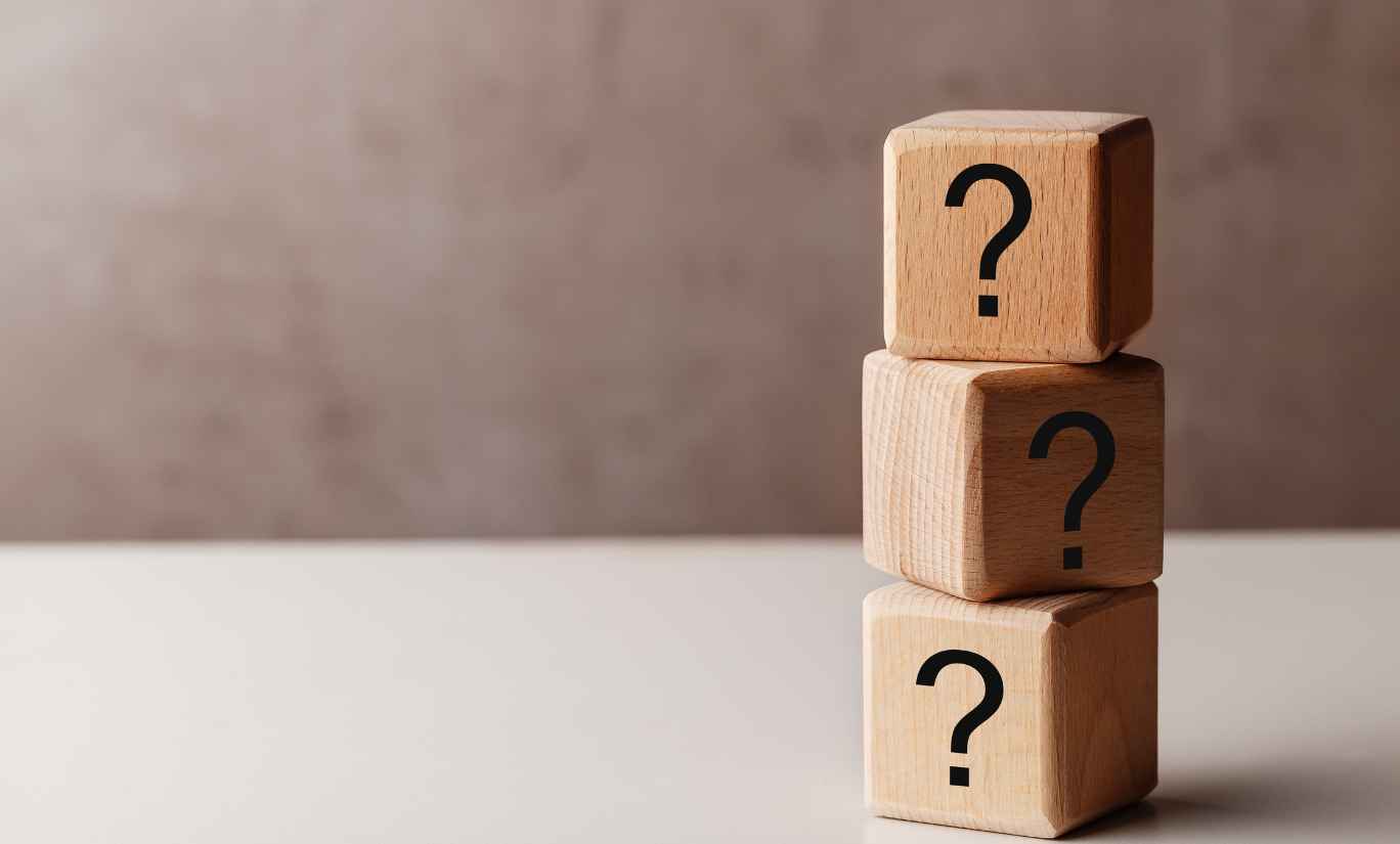 Wooden blocks with question marks stacked up