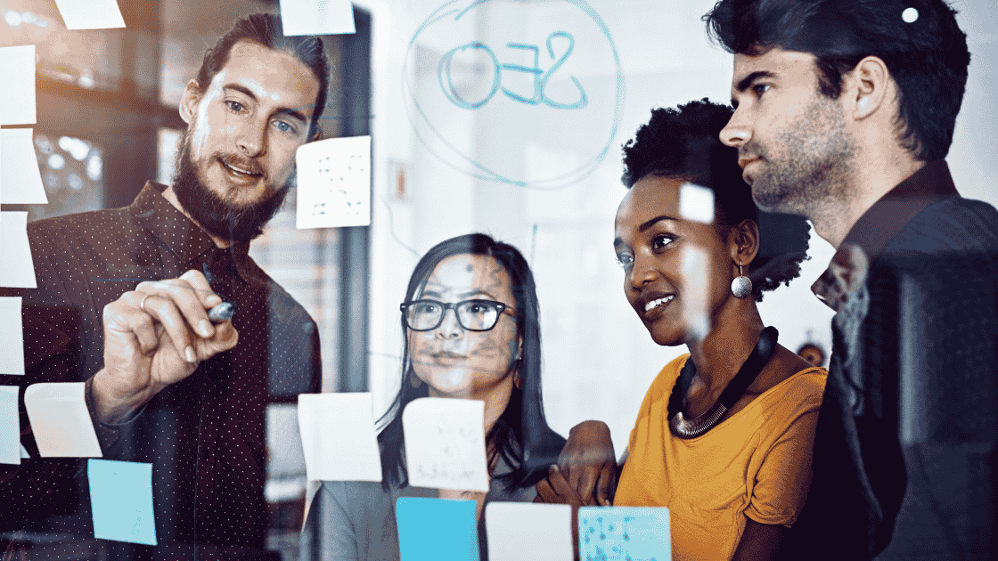 Office workers aronud a meeting board