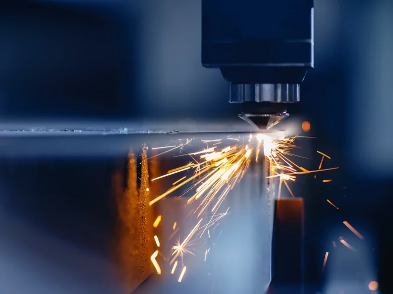A machine cutting metal, creating bright sparks as it works.