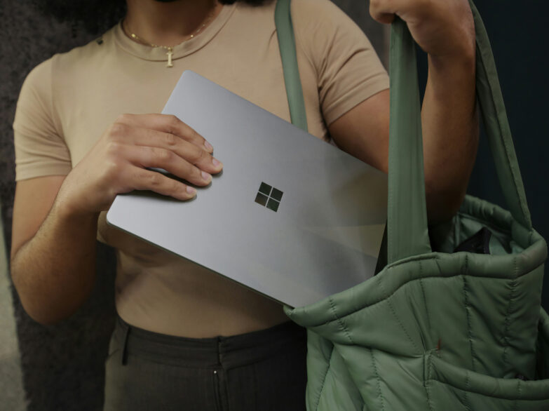 Girl putting her Microsoft Surface Laptop 3 in her bag.
