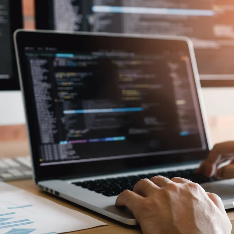 A person focused on typing on a laptop computer, with hands on the keyboard.