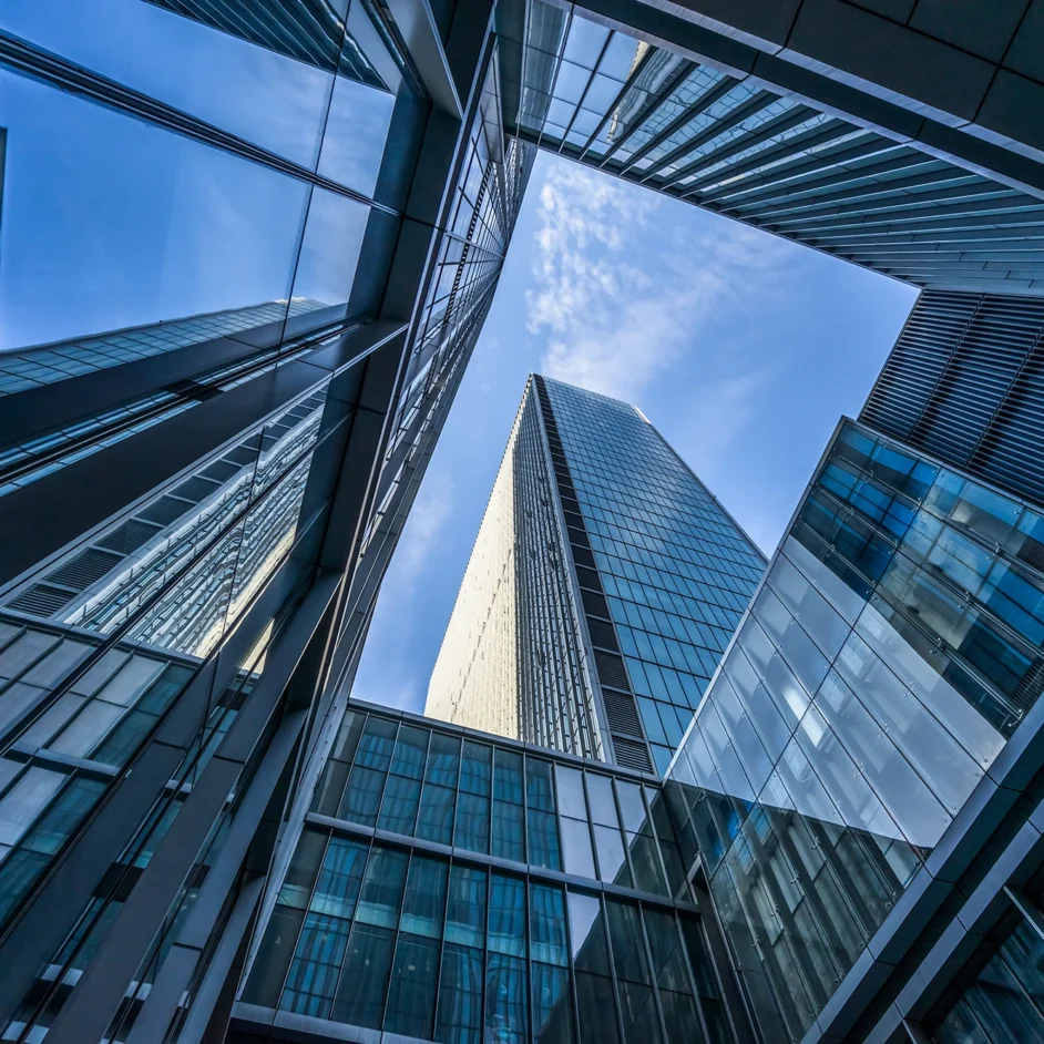 View from the top of a building, showcasing the skyline and surrounding landscape under a clear blue sky.