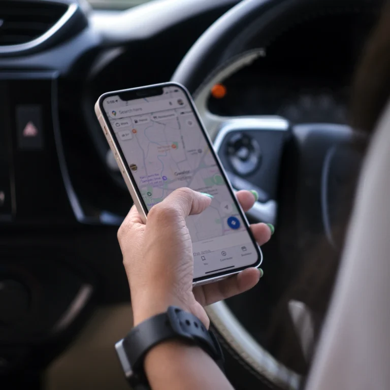 A woman in a car looking at Google maps on her phone.