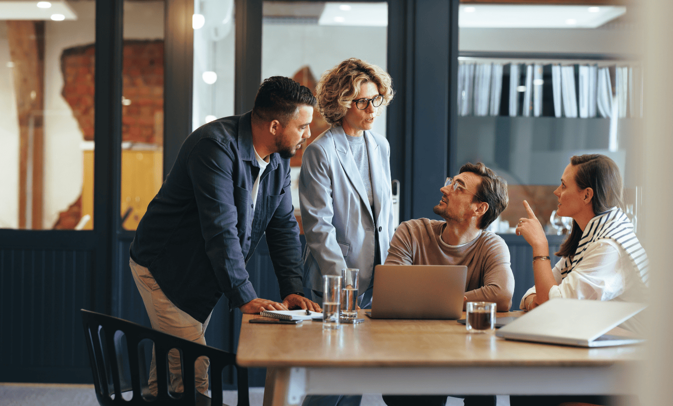 Office workers talking around a laptop